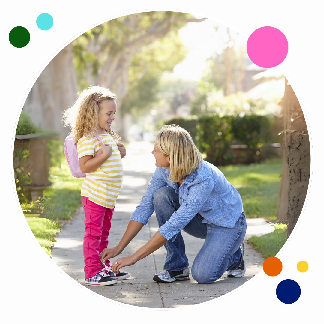 Mom tying daughter's shoe