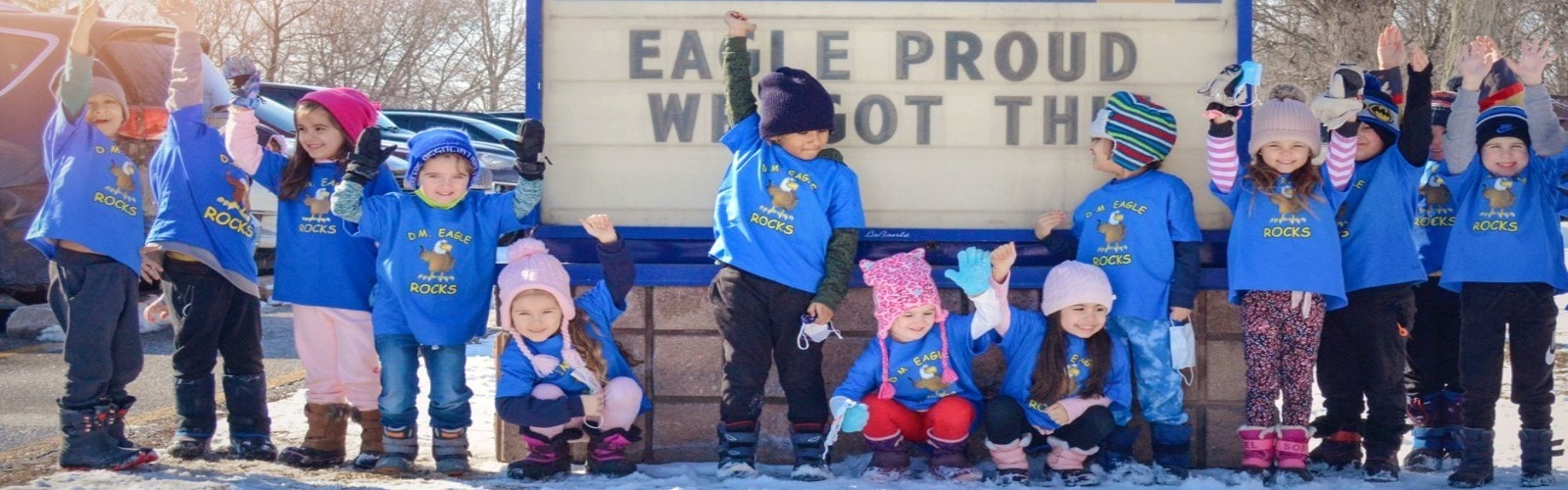 Kids standing in front of a DM Eagle sign