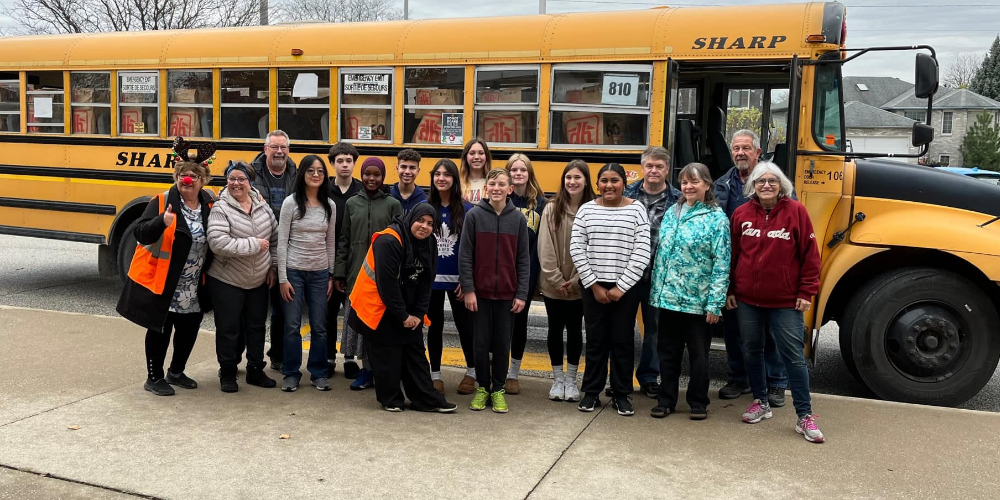 Students and staff in front of school bus